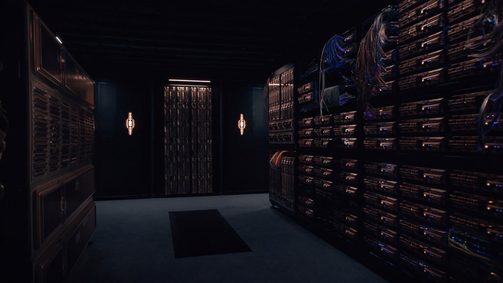 Server racks and bundled network cables in a dark server room.